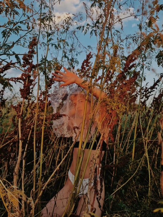 two people posing by trees in mesh clothing