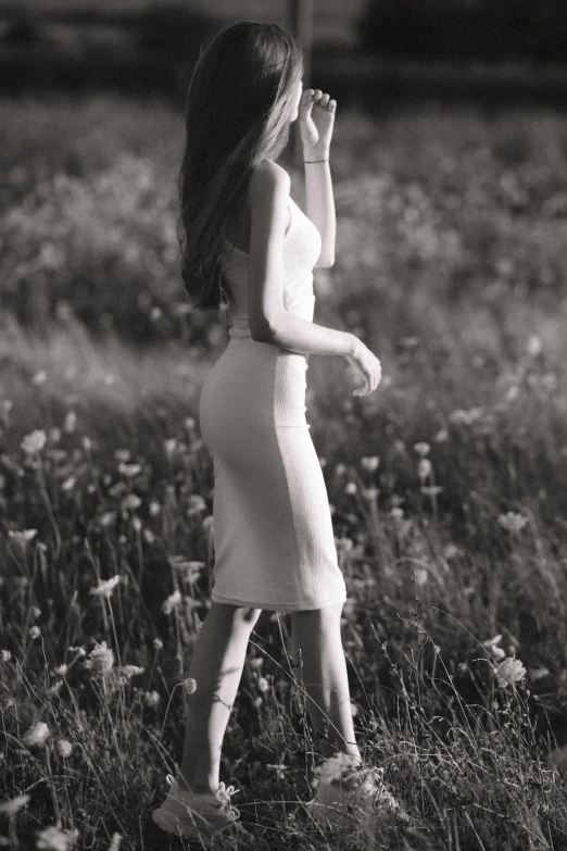 black and white pograph of woman in field with flowers