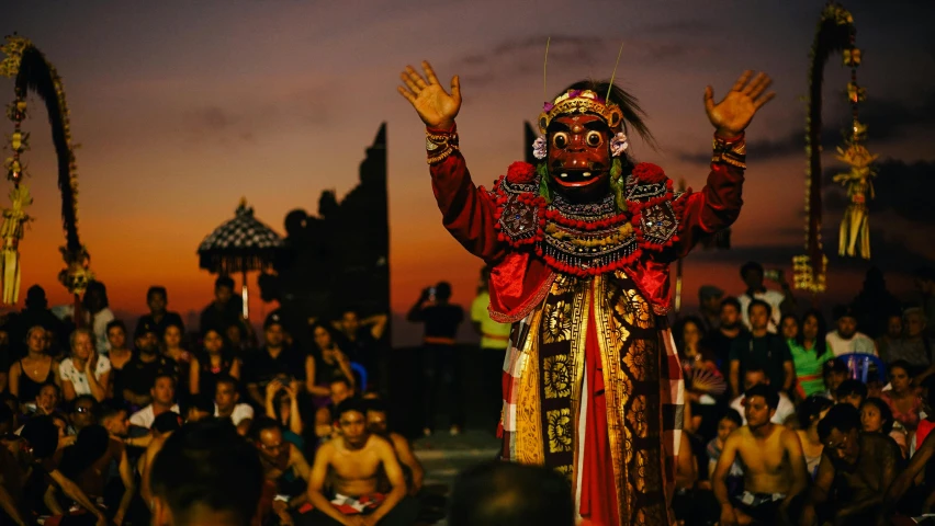 people watching a man in a traditional dance costume