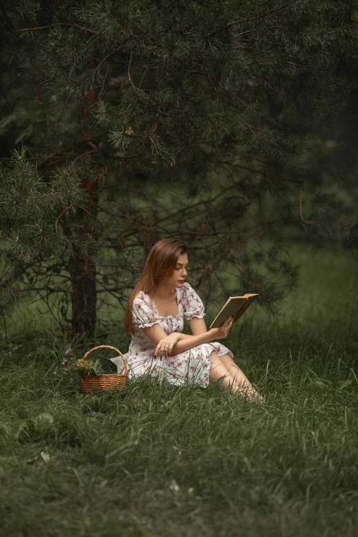 the girl in a white dress sits and reads