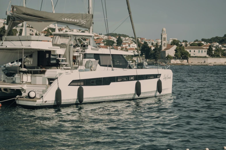 a white catamaran sitting in the water near a dock