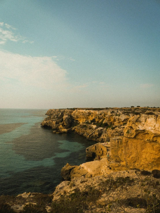 a man is looking over the water at the cliffs