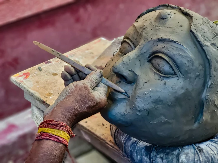 a person working with clay on a piece of artwork