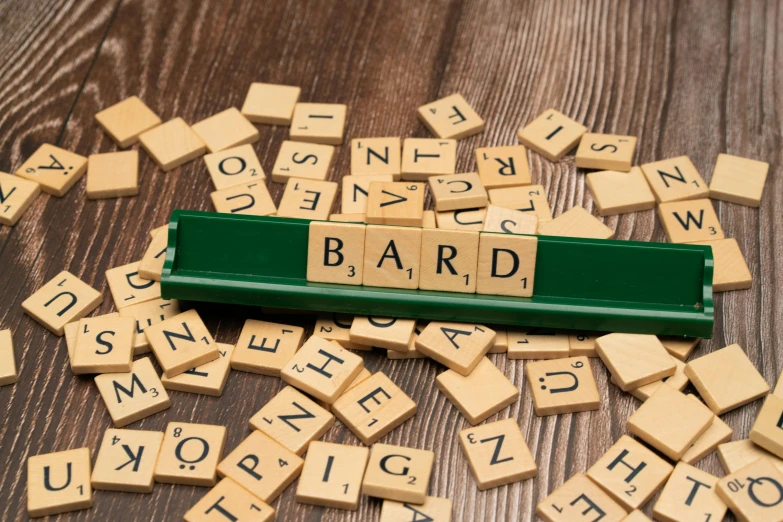 scrabble letters spelling the word bard are arranged around a game