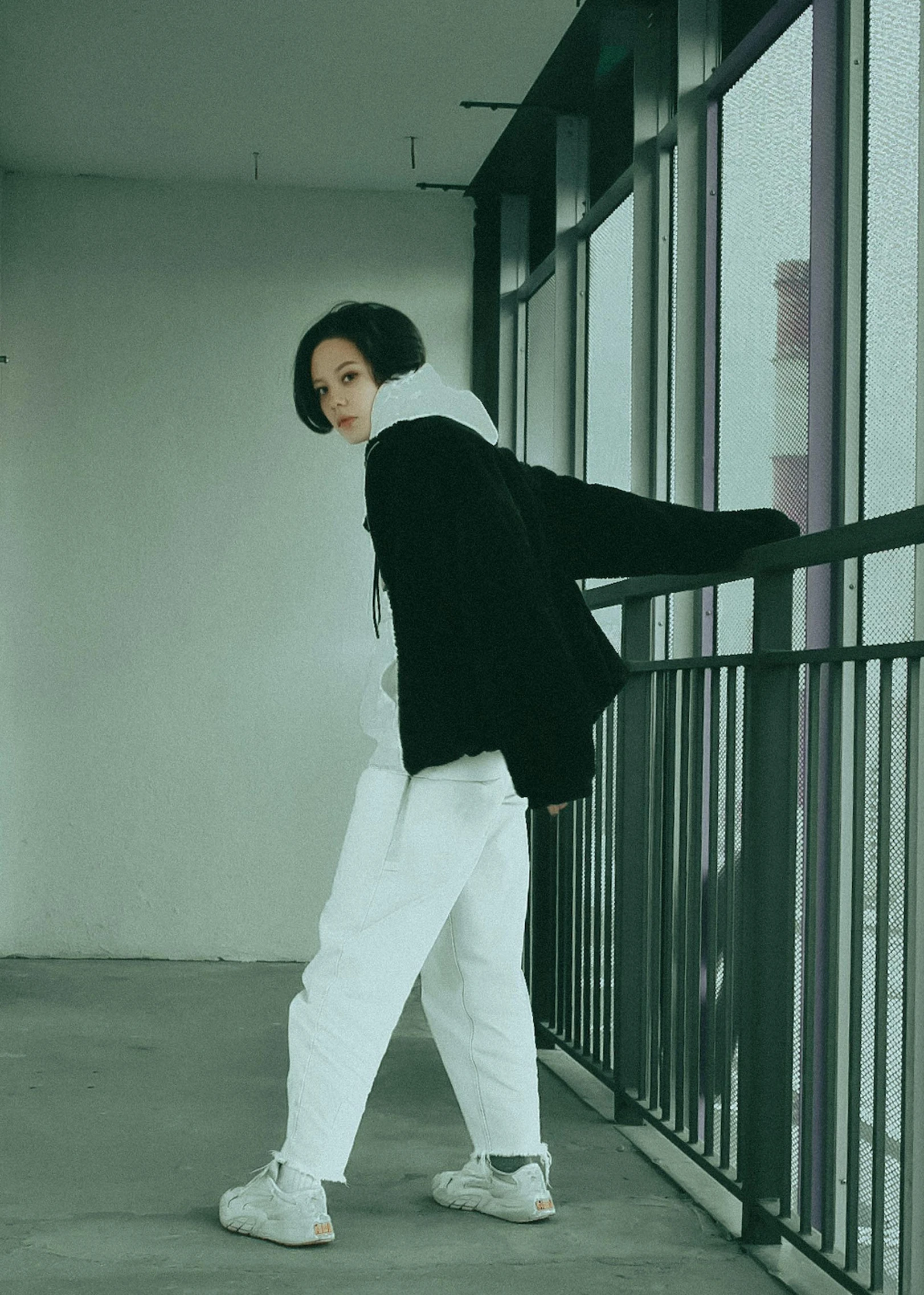 an asian woman wearing white pants and white sneakers