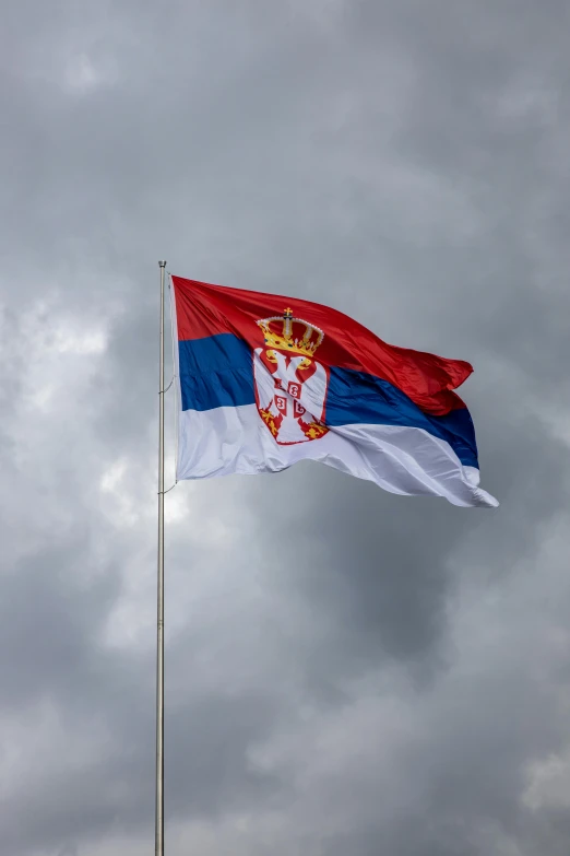 the flag of the city of moscow is flying high in the cloudy sky