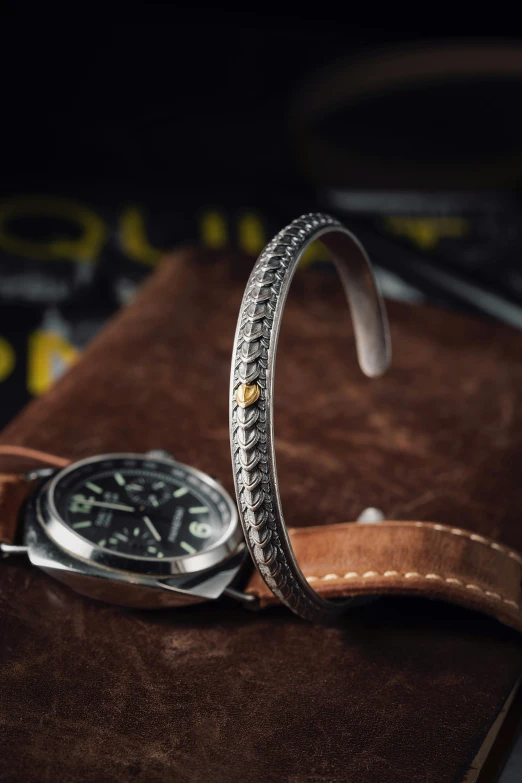 a watch and leather case that is laying on a table