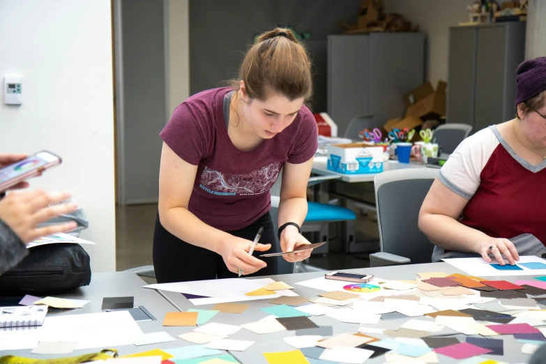 women working on art work with post - it notes