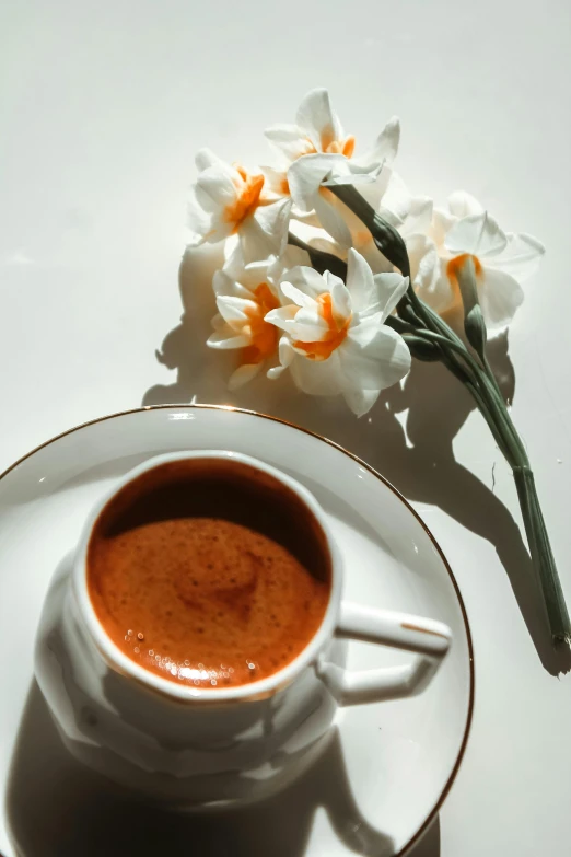 flowers are sitting next to a cup of chocolate