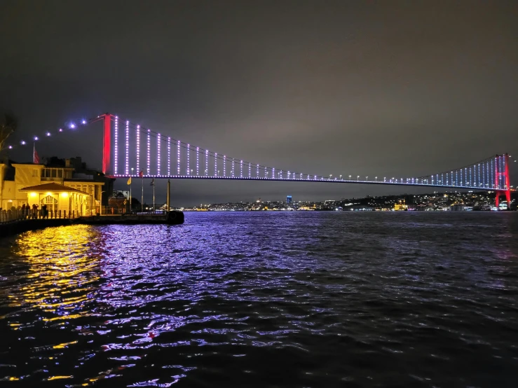 a long s of the bay bridge and its lights shining brightly in the dark