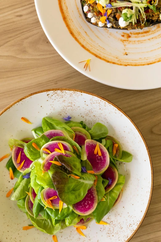 two plates have food on them along with the bowl