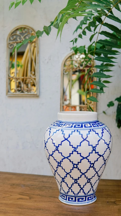a vase with a blue and white design sits on a table