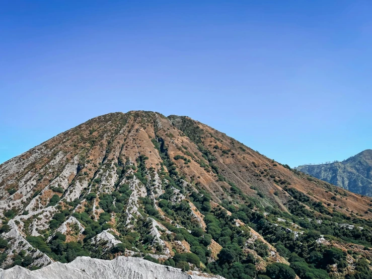 a tall rocky mountain next to the water