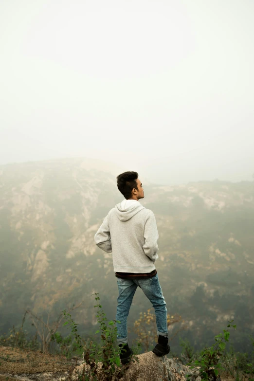 a man standing on top of a hill next to mountains