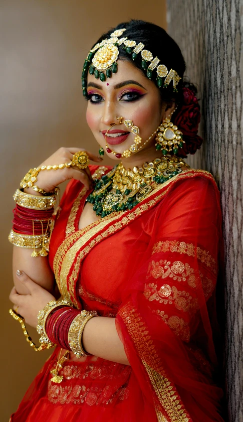 a woman in traditional indian costume is holding her arms together