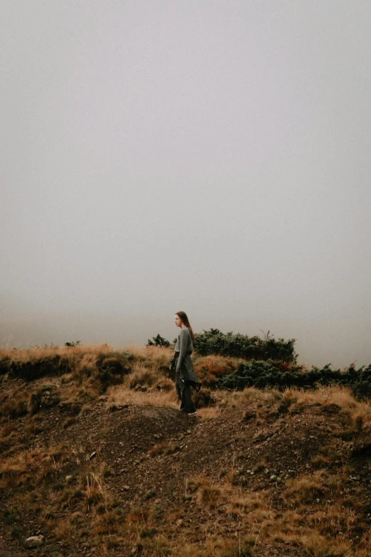 a person walking across a grass covered field