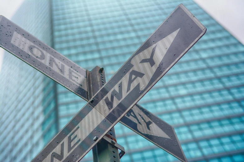 a traffic sign near a tall building that reads east 42nd