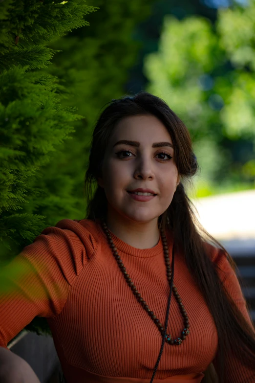 a girl wearing an orange shirt looking into the camera