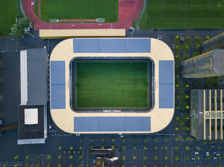 an aerial po of a stadium with green grass and blue tiled walls