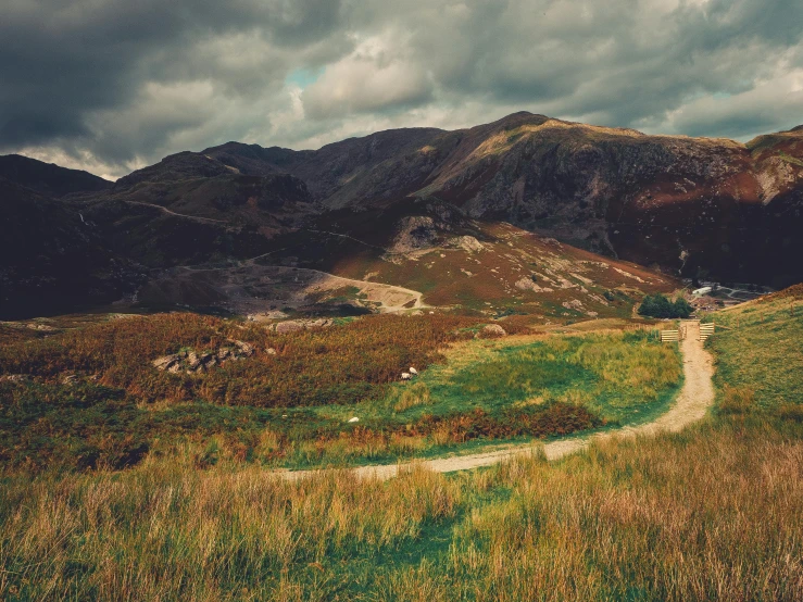 the mountains that are shown behind a dirt path