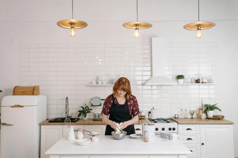 a woman in a black apron is preparing food on the kitchen counter