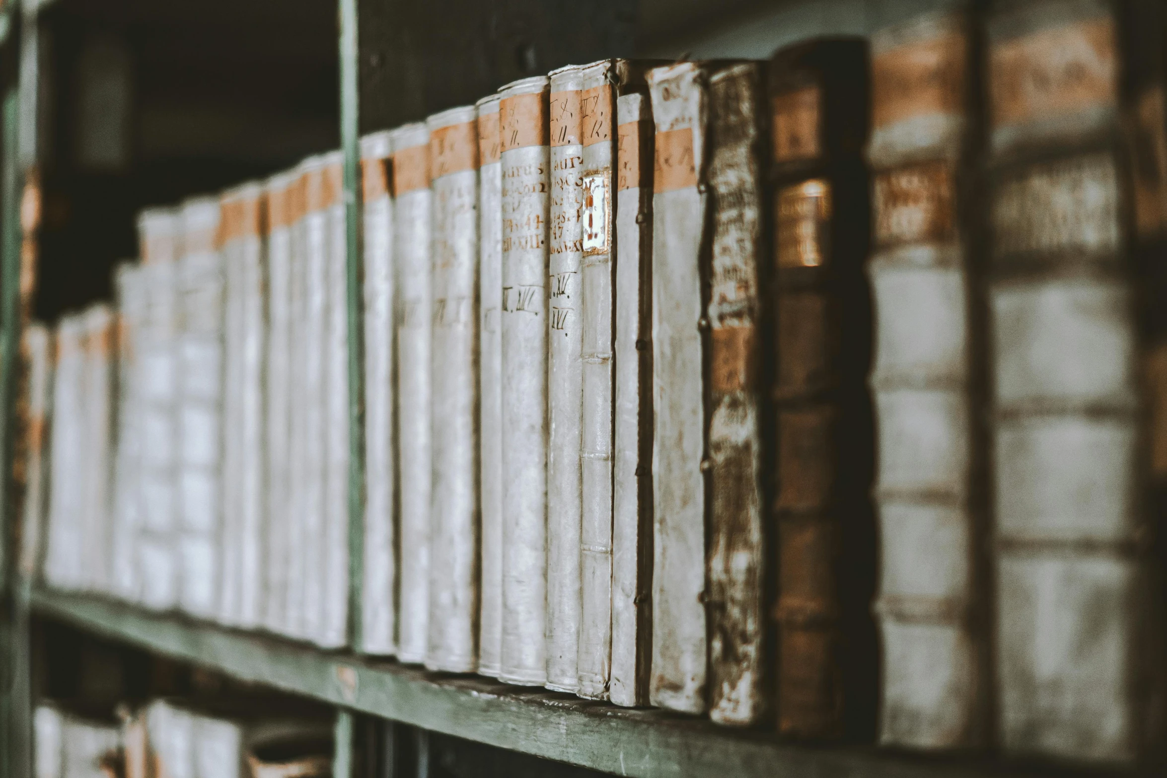 several stacks of books are stacked up on a shelf