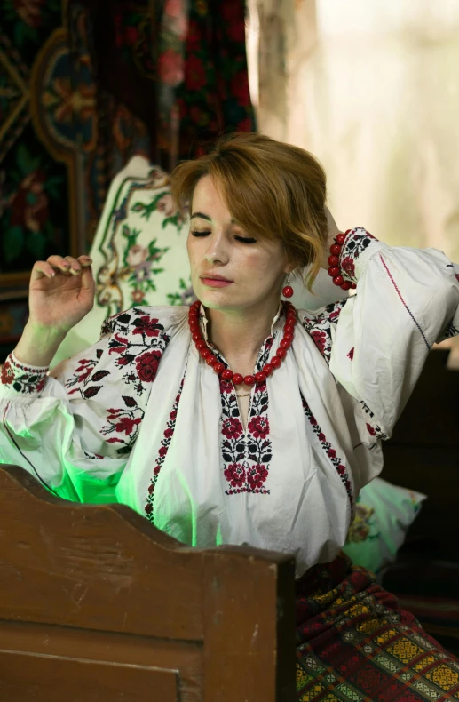 a woman wearing some ethnic attire posing in front of a table