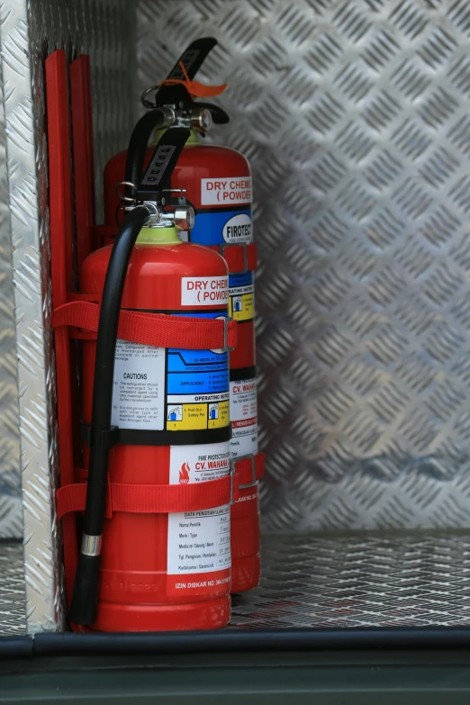 red fire hydrant and hose are on top of the wall