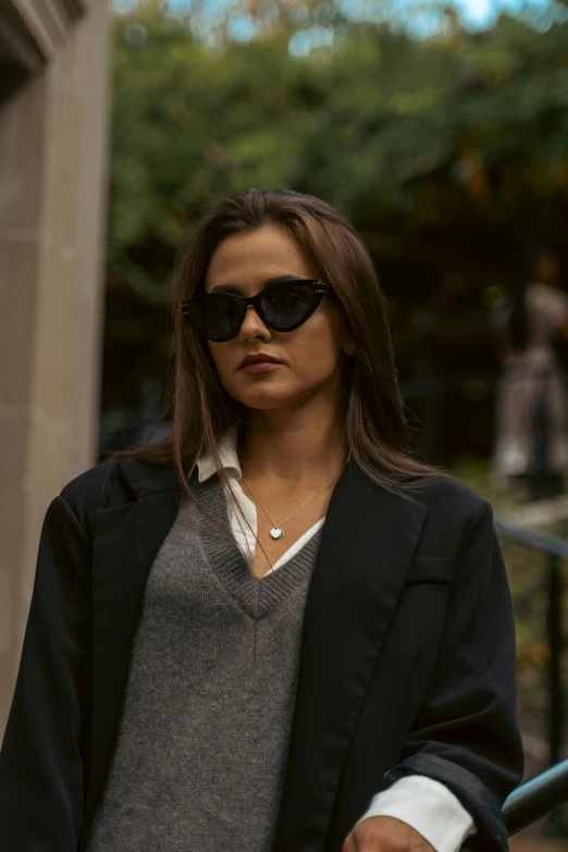 a young woman with sunglasses standing outside a building