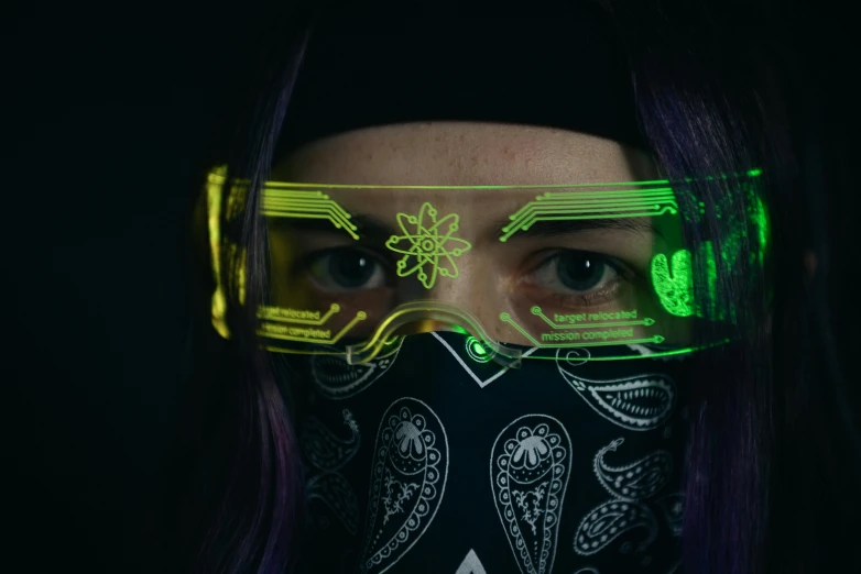 a woman with blue hair and green glowing goggles wearing green light up glasses