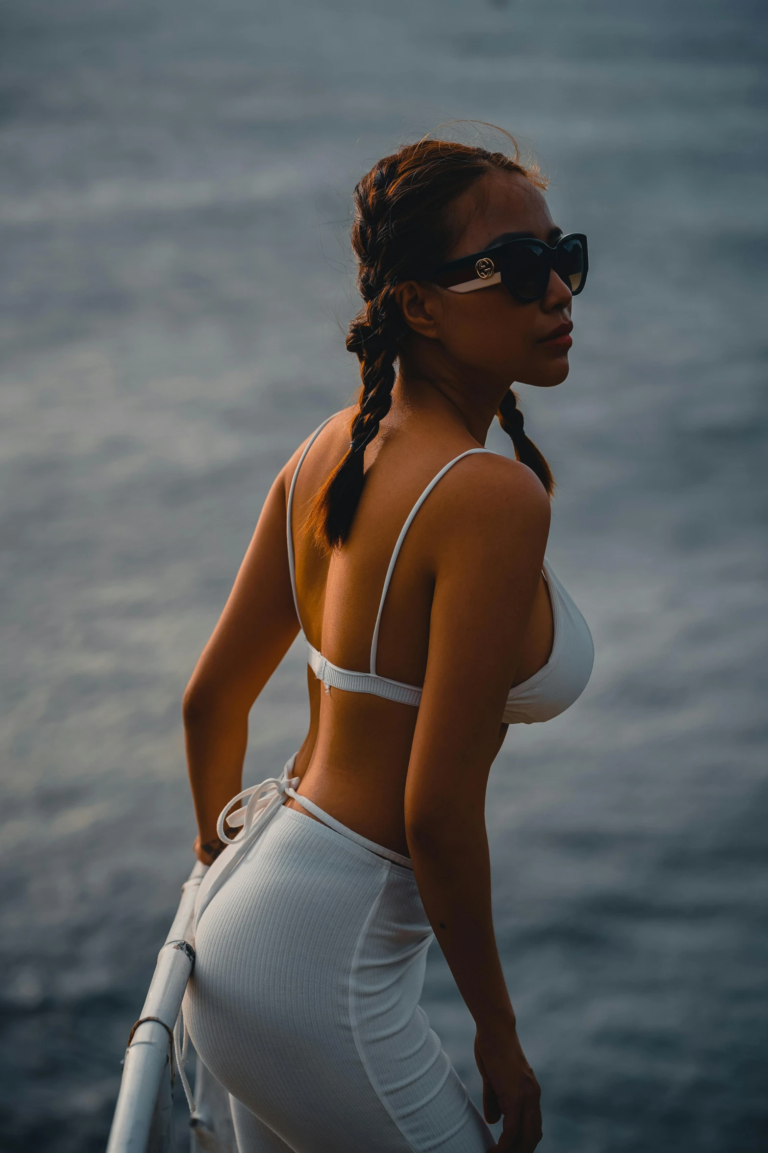 a black woman wearing a white bikini top is posing