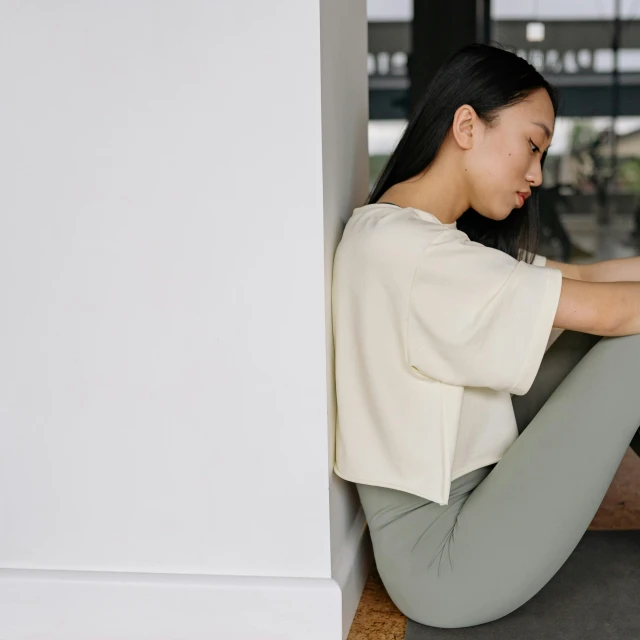 a woman sitting on the floor near a doorway