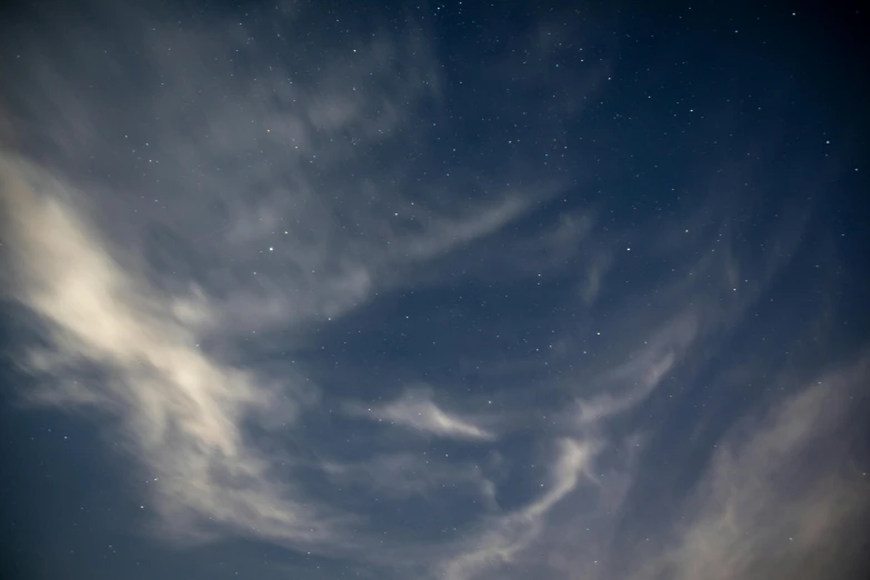 the moon and star trails across a dark blue sky