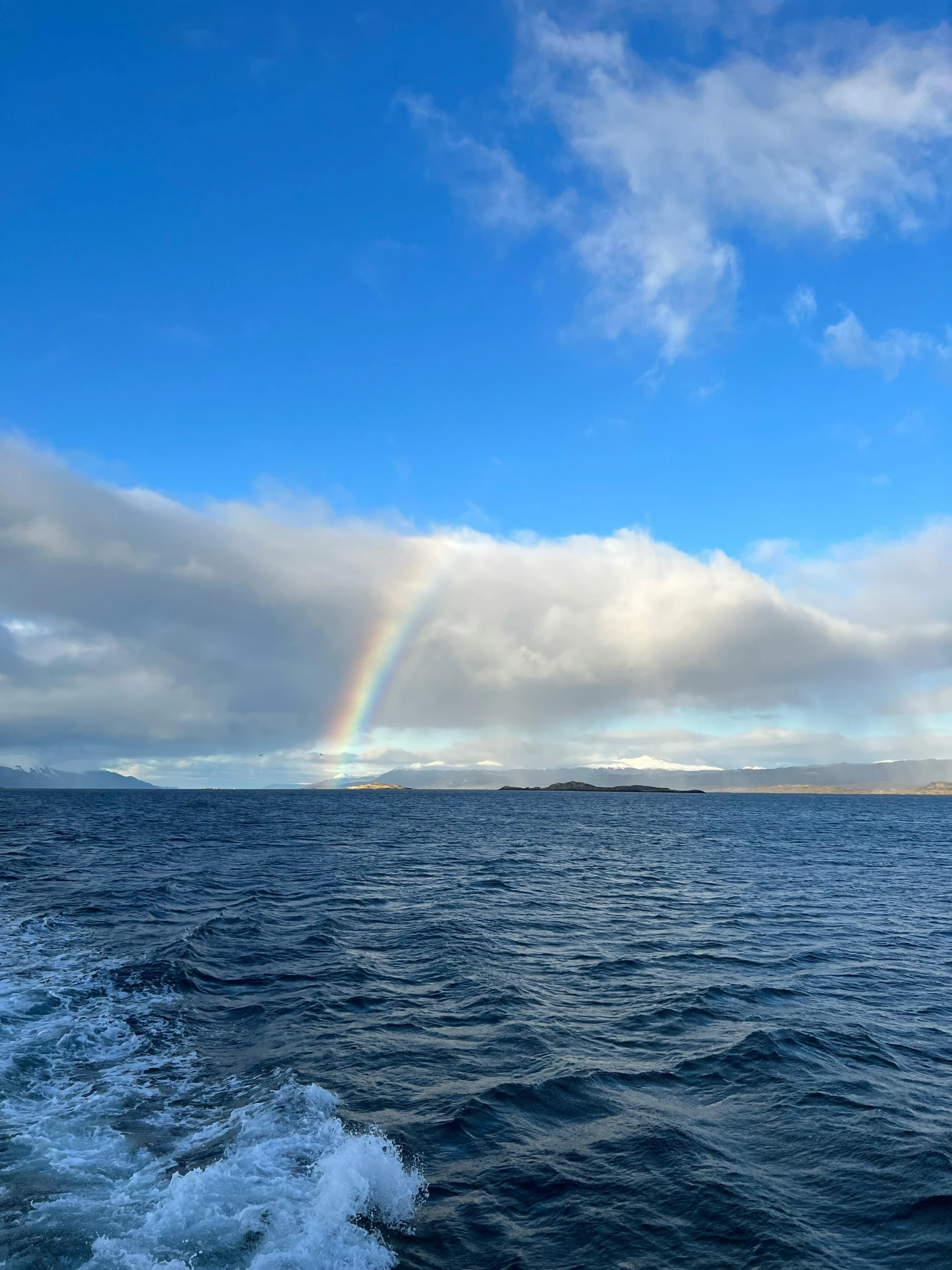 an open ocean with a rainbow on the horizon