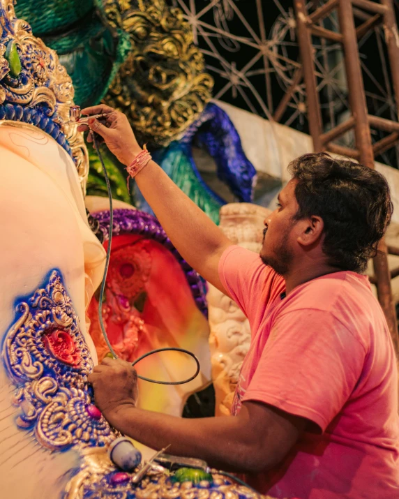 the man is decorating an elaborately decorated statue