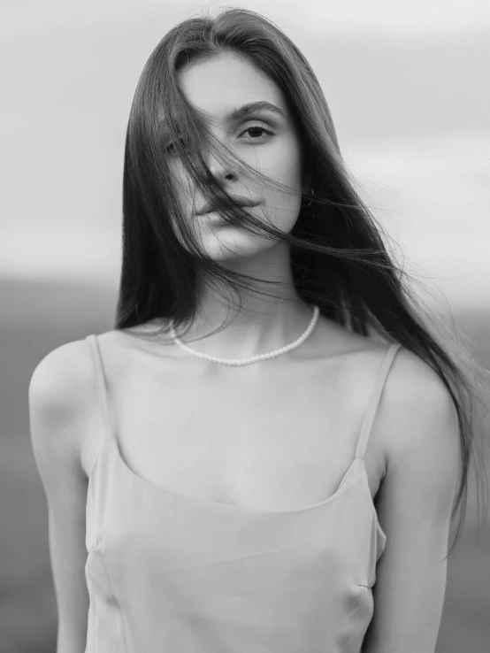 woman standing in white tank top posing for a po