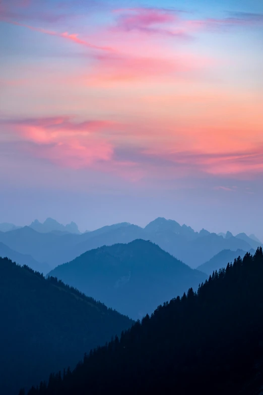 mountains under an orange and blue sky with some clouds