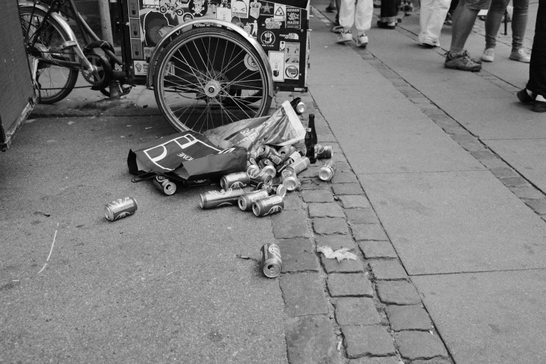 this black and white po shows a trash heap outside with a broken bicycle wheel