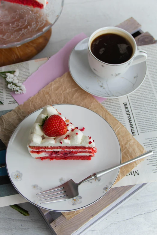 a piece of cake on a plate next to a cup of coffee