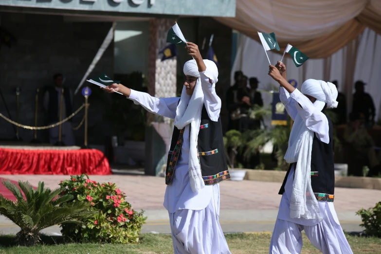 some women in traditional dress are holding flags and waving