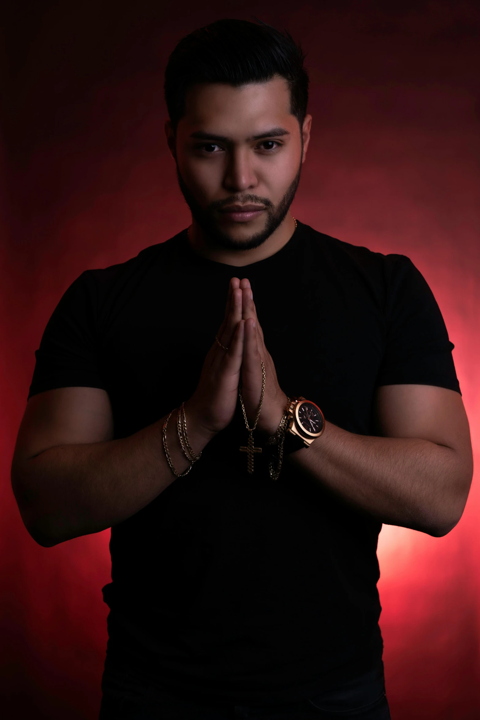 a person with his hands clasped wearing some gold jewelry