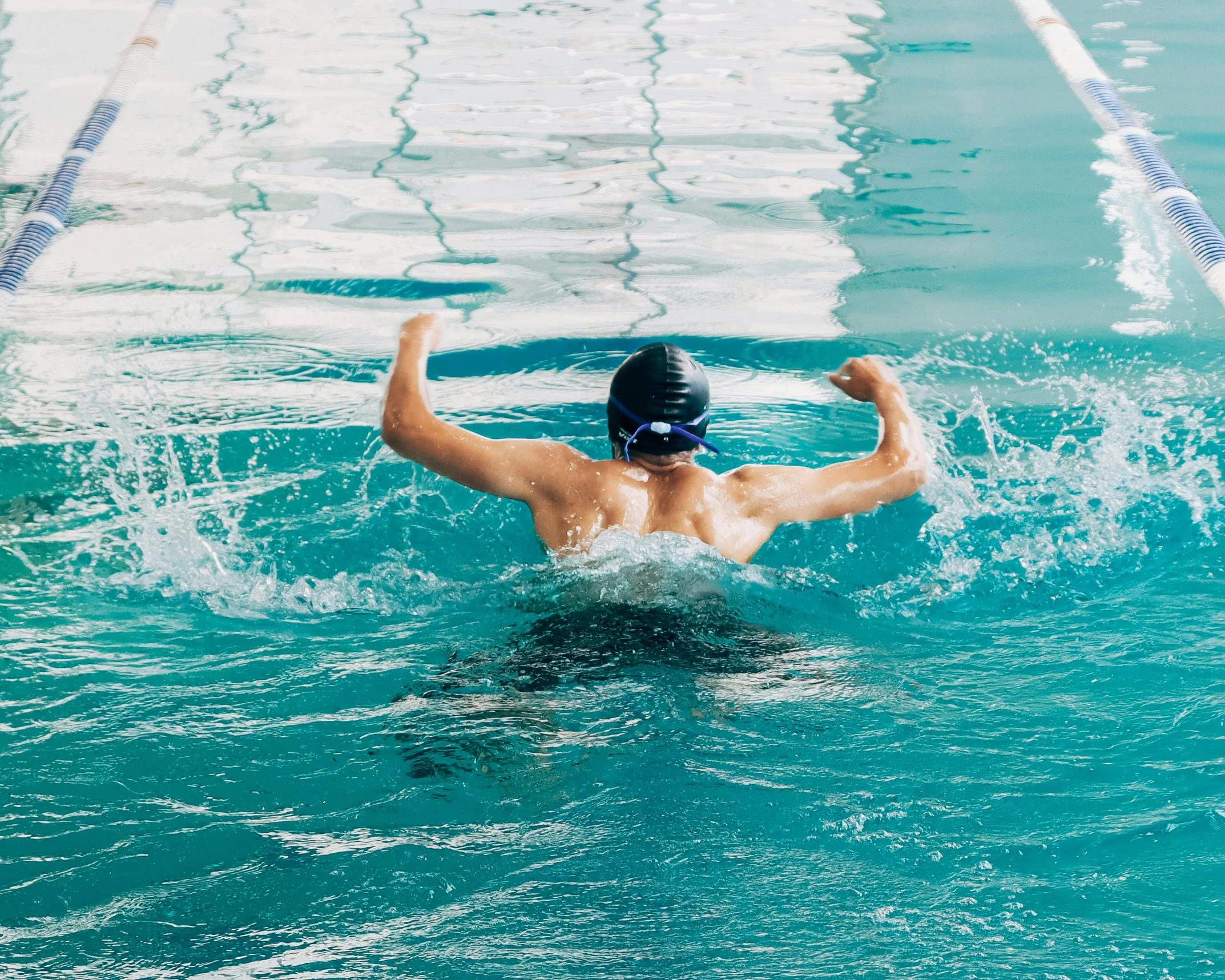 a man is in the pool wearing a swim cap