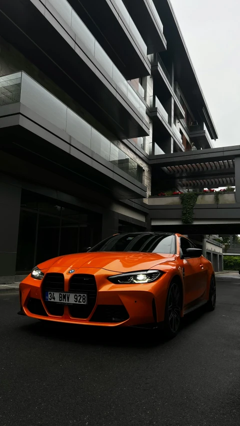 an orange sports car parked in front of a large building