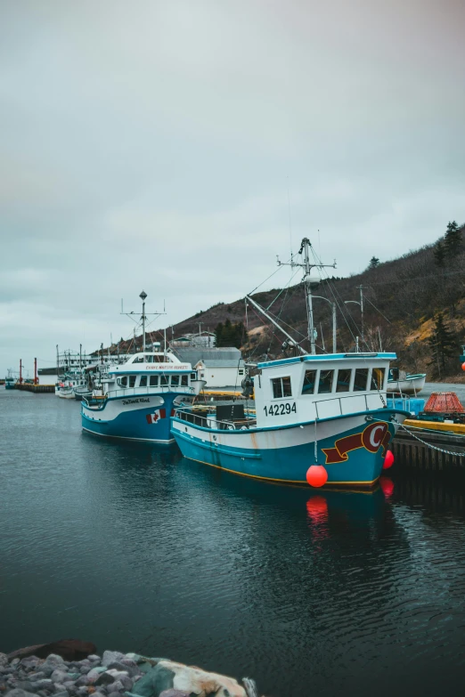 some boats docked near some cliffs on a lake