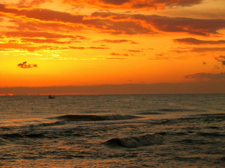 a boat out on the water at sunset