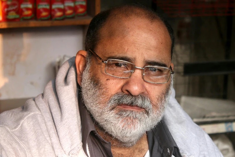 a man with glasses and a beard in the process of a portrait