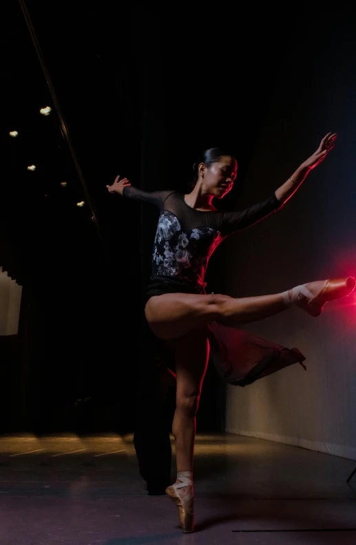 a woman dancer is lit by a light that reads lights up