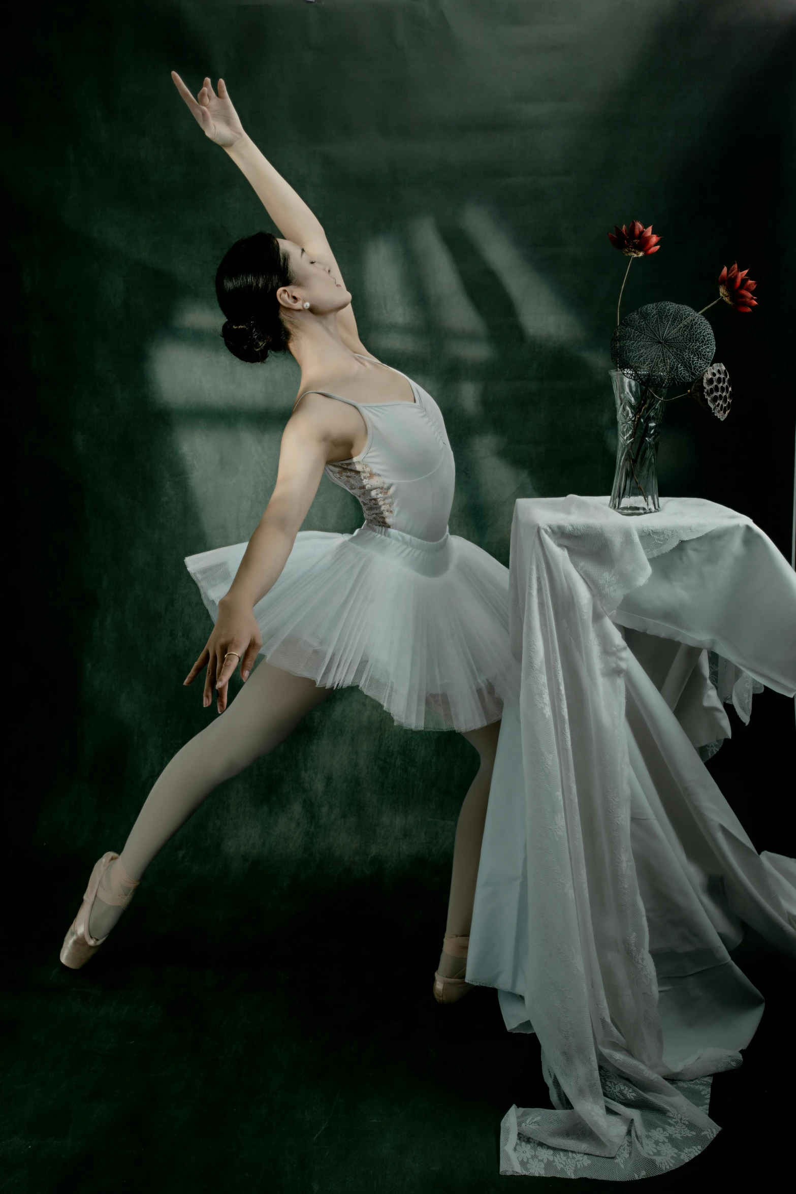 a young ballerina dancing in front of a dark backdrop