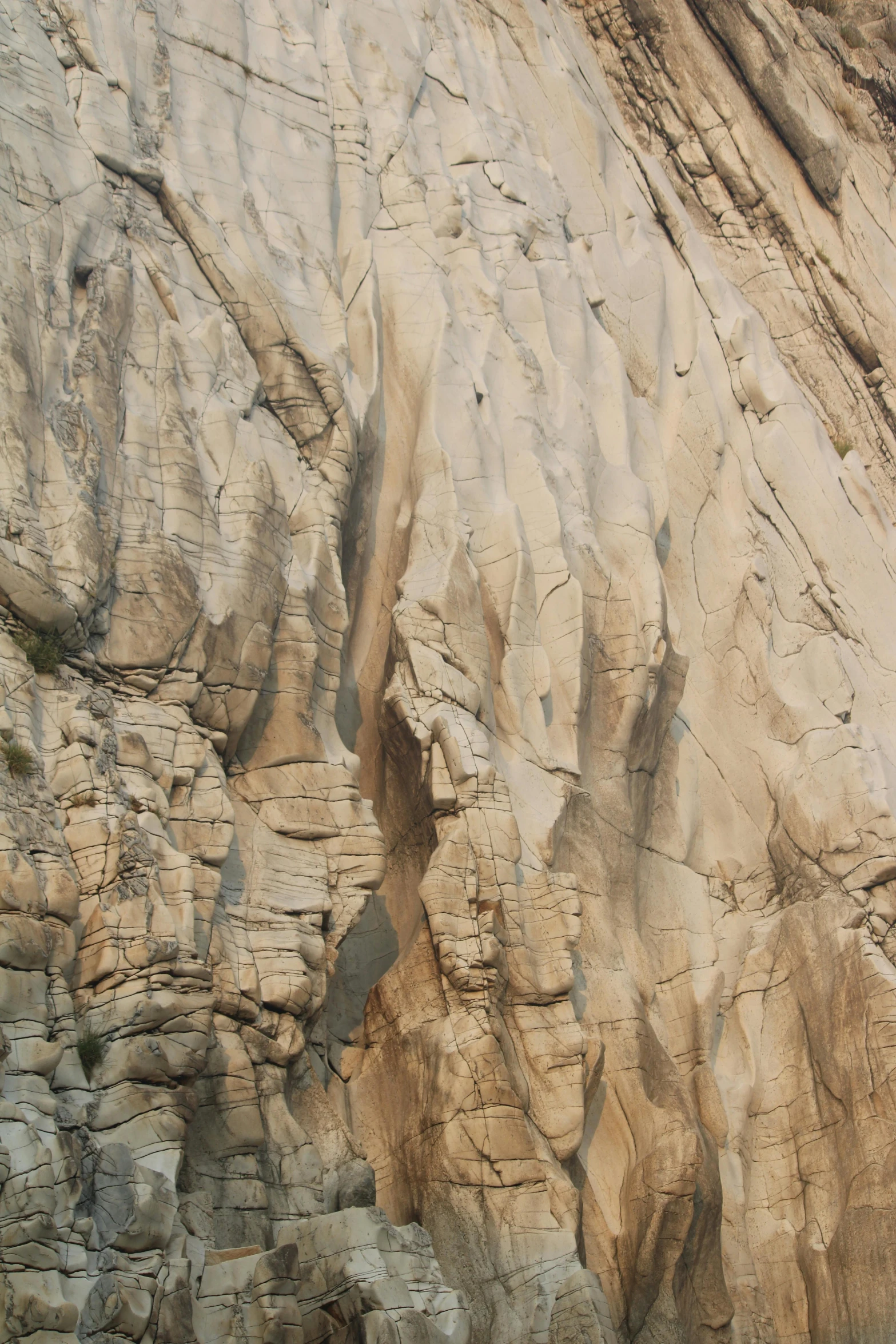 a man in a wet suit and white hat standing on the cliff side