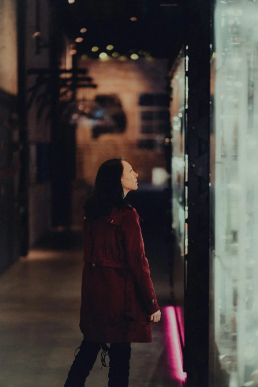 woman standing in hallway looking at tall glass display case